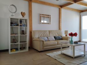 ein Wohnzimmer mit einem Sofa und einem Tisch in der Unterkunft Marina Oceano in La Mareta