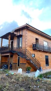 una casa de madera con escaleras delante en Homestay ANEMON en Dieng