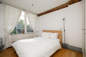 um quarto com uma cama branca e uma janela em Shard View near Borough Market em Londres