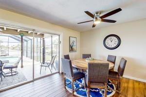 a dining room with a table and chairs and a clock at Sunny Side Up in Cape Coral