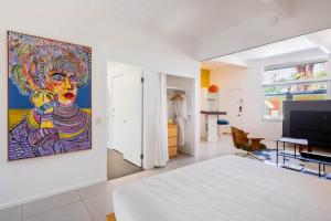een slaapkamer met een groot schilderij aan de muur bij Historic Desert Star in Palm Springs