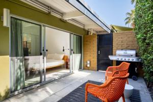 een terras met twee oranje stoelen en een slaapkamer bij Historic Desert Star in Palm Springs