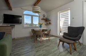 a living room with a table and chairs and a tv at MIMOZA2 in Novi Vinodolski