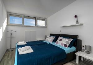 a bedroom with a large bed with blue sheets and pillows at MIMOZA2 in Novi Vinodolski
