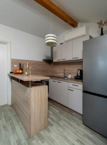 a kitchen with white cabinets and a refrigerator at MIMOZA2 in Novi Vinodolski
