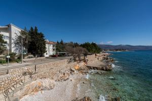 a stone wall next to a body of water at MIMOZA2 in Novi Vinodolski