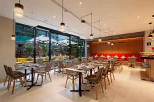 um restaurante com mesas e cadeiras num quarto em Ikonik Miraflores em Lima