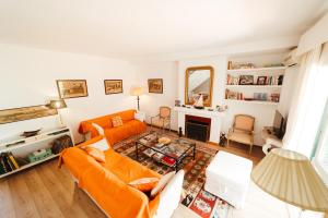 een woonkamer met een oranje bank en een open haard bij Andalusian beach haven villa in El Puerto de Santa María