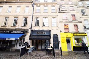 a building with a sign for a show on a street at Heart of Bath: Kingsmead Apartment in Bath