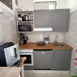 une petite cuisine avec un évier et un micro-ondes dans l'établissement Grado Laguna Apartment, à Grado