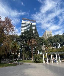 a palm tree in a park with a tall building at MENDOZA Suites 1 -con estacionamiento opcional- in Mendoza