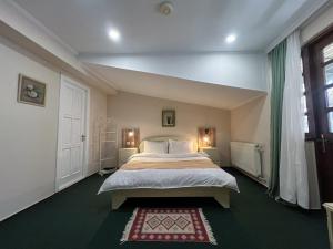 1 dormitorio con cama grande y ventana grande en Madera Hotel, en Tiflis