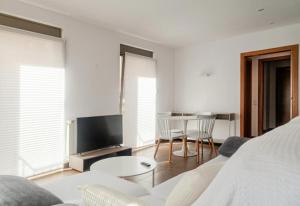 a living room with a couch and a tv and a table at Residential Tourist Apartments in Caldes d'Estrac