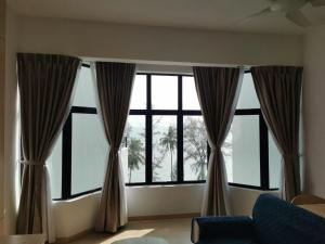 Mutiara Melaka Beach Resort في Tangga Batu: نافذة كبيرة مع ستائر في غرفة المعيشة