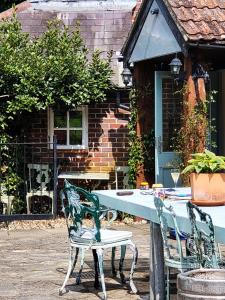 twee stoelen en een tafel voor een huis bij escape the ordinary - Piddle Inn the Home private self cater holiday in Dorchester