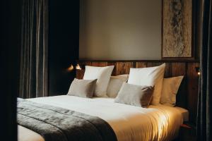 a bedroom with a bed with white sheets and pillows at Charmaix by Lodji in Saint-Martin-de-Belleville