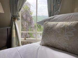 a bed with a pillow in front of a window at Bryn Guest House in Conwy
