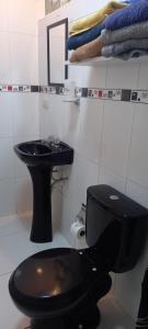baño con aseo negro y lavamanos en Apartamento en zona residencial de San Miguel Lima, en Lima