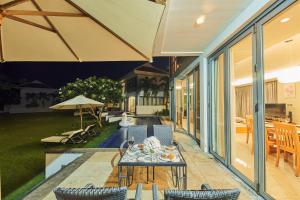 un patio con mesa, sillas y sombrilla en Ocean Beach Resort Da Nang en Da Nang