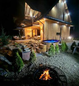 a fire pit in front of a house at night at Vidokówka Resort in Waksmund