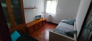 una pequeña sala de estar con TV y silla en PM70 Apartment, en San Sebastián