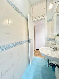 Baño blanco con lavabo y espejo en Appartamento Elena, en Cefalú