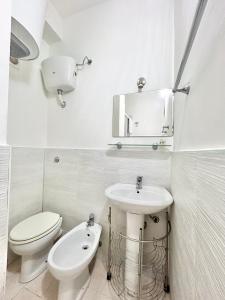 Baño blanco con aseo y lavamanos en Appartamento Elena, en Cefalú
