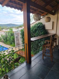 balcón con mesa, sillas y vistas en Casa Bonita - Aconchegante para se divertir e descansar, en Pirenópolis