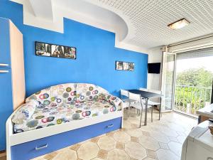 Dormitorio azul con cama y mesa en Appartamento Elena, en Cefalú