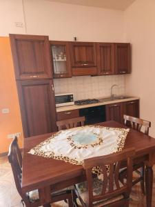 eine Küche mit einem Holztisch mit einem Tischtuch drauf in der Unterkunft Appartamento Giardino in Domus de Maria
