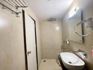 uma casa de banho com um lavatório e um chuveiro em HOTEL SARC ! VARANASI - Forɘigner's Choice ! fully Air-Conditioned hotel with Lift & Parking availability, near Kashi Vishwanath Temple, and Ganga ghat 2 em Varanasi