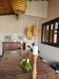 una mesa de comedor con una vela encima en Casa Bonita - Aconchegante para se divertir e descansar, en Pirenópolis