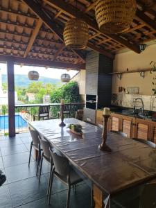 una cocina con una gran mesa de madera y sillas en Casa Bonita - Aconchegante para se divertir e descansar, en Pirenópolis
