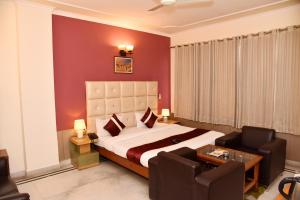 um quarto com uma cama, um sofá e uma mesa em Hotel Gracious em Gurgaon