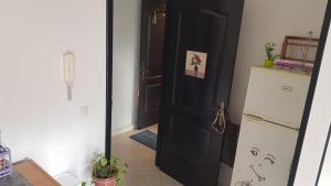 eine Küche mit einer schwarzen Tür und einem Kühlschrank in der Unterkunft Mouad house in Martil