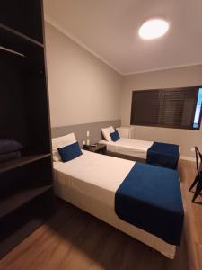 um quarto de hotel com duas camas e uma janela em Hotel Bella Paulista em São Paulo