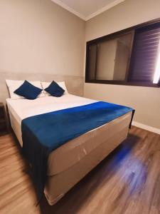 um quarto com uma cama grande e lençóis azuis em Hotel Bella Paulista em São Paulo