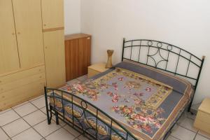 ein Schlafzimmer mit einem Bett mit einer Blumendecke darauf in der Unterkunft Appartamento con vista incantevole sul mare in Chiesa Vetusa