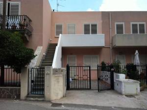 ein rosafarbenes Gebäude mit einem Tor und einer Treppe in der Unterkunft Appartamento con vista incantevole sul mare in Chiesa Vetusa