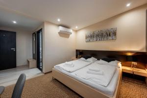 1 dormitorio con 1 cama blanca grande y escritorio en Hotel Zlaté Košice, en Košice