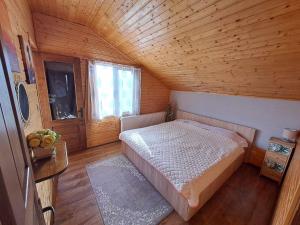 - une chambre avec un lit dans une pièce en bois dans l'établissement Cabana Baile Figa, à Beclean