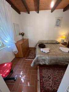 um pequeno quarto com uma cama e uma cadeira vermelha em Casa Vacanza appartamento Tortolì-Arbatax a 14 minuti dal mare em Tortolì
