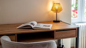 a desk with a book and a lamp on it at Le Nid - hébergement cosy in Dijon