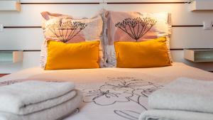 - une chambre avec un lit et des oreillers jaunes dans l'établissement Le Nid - hébergement cosy, à Dijon