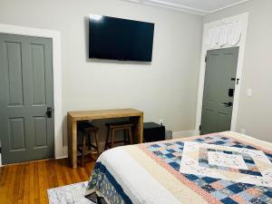 um quarto com uma cama e uma televisão na parede em The Tellico Plains Inn and Event Venue em Tellico Plains