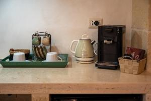 a counter top with a coffee maker and a tea kettle at le CASINE di MARUGGIO 19 in Maruggio