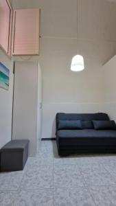 a living room with a blue couch and a lamp at Economy Guest House in Gallipoli
