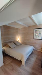 1 dormitorio con 1 cama grande en una pared de madera en la bergerie des colles, en Entrecasteaux