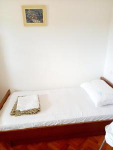 a bed in a room with a picture on the wall at Apartman SunnySide in Rogoznica