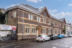 a large brick building with cars parked in front of it at Madison House - Converted Church 5 Bed Pontypool in Pontypool